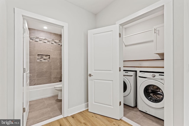 laundry room with separate washer and dryer and cabinets