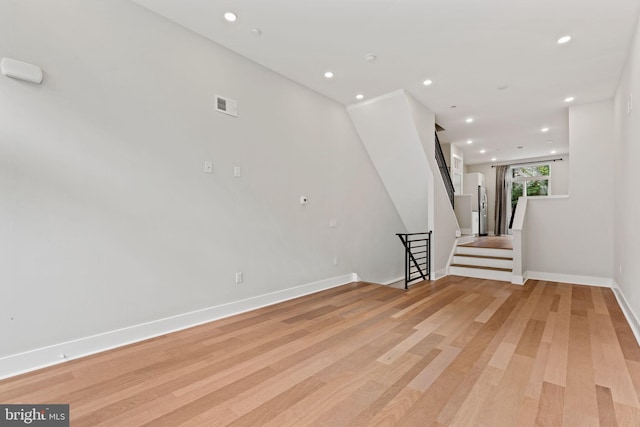 unfurnished room featuring light wood-style floors, recessed lighting, visible vents, and stairs