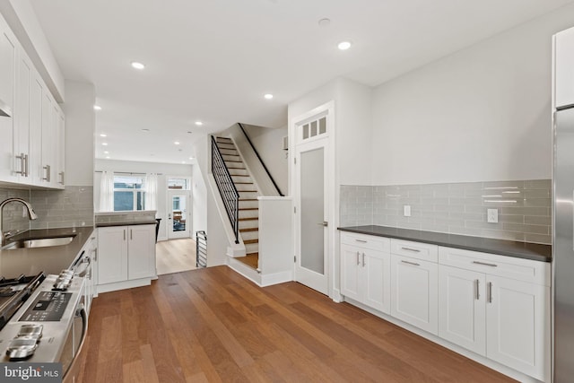 kitchen featuring sink, white cabinetry, tasteful backsplash, and light wood-type flooring