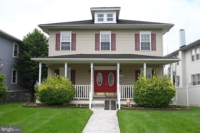 view of front of home with a front yard and covered porch