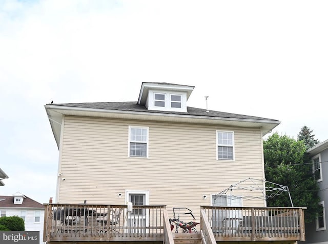 rear view of house featuring a wooden deck