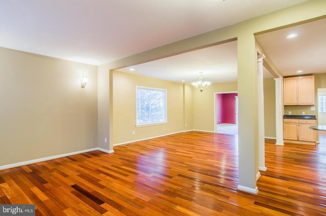 unfurnished living room with hardwood / wood-style flooring and a notable chandelier