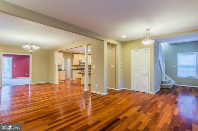 unfurnished living room with dark hardwood / wood-style flooring and a notable chandelier