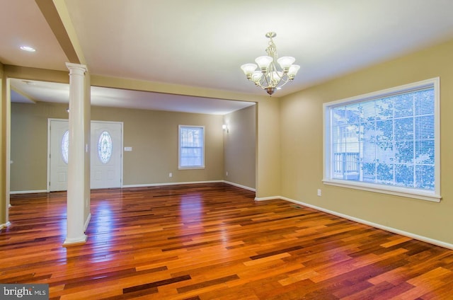 unfurnished room featuring hardwood / wood-style floors and an inviting chandelier