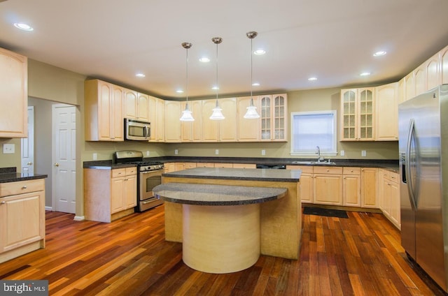 kitchen featuring pendant lighting, a center island, dark wood-type flooring, sink, and stainless steel appliances