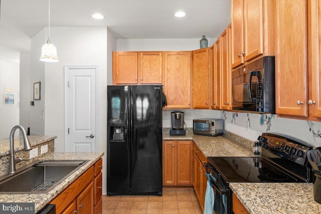 kitchen with pendant lighting, black appliances, sink, light stone countertops, and light tile patterned floors