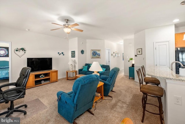 living room with light carpet, sink, and ceiling fan