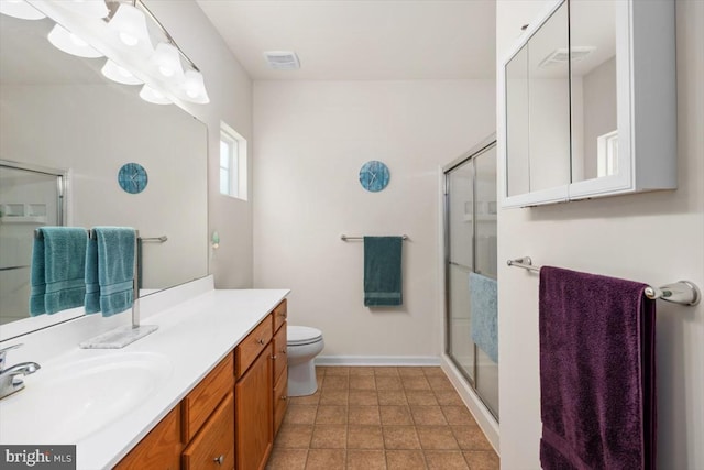 bathroom featuring tile patterned floors, vanity, toilet, and an enclosed shower