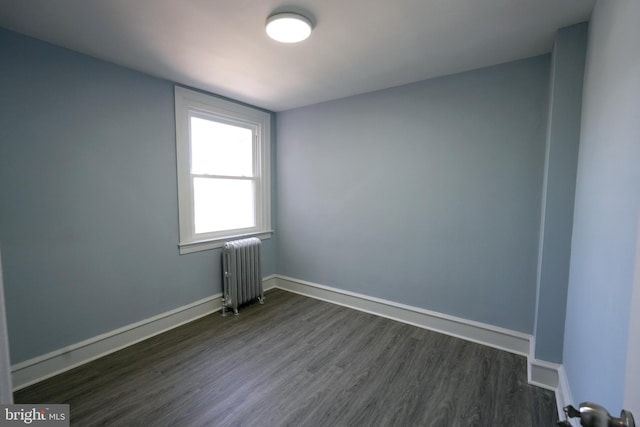 unfurnished room with dark hardwood / wood-style flooring and radiator