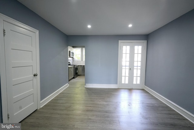 empty room with dark hardwood / wood-style flooring and french doors