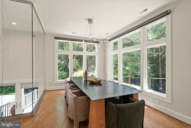 dining room with light wood-style flooring, an inviting chandelier, visible vents, and baseboards