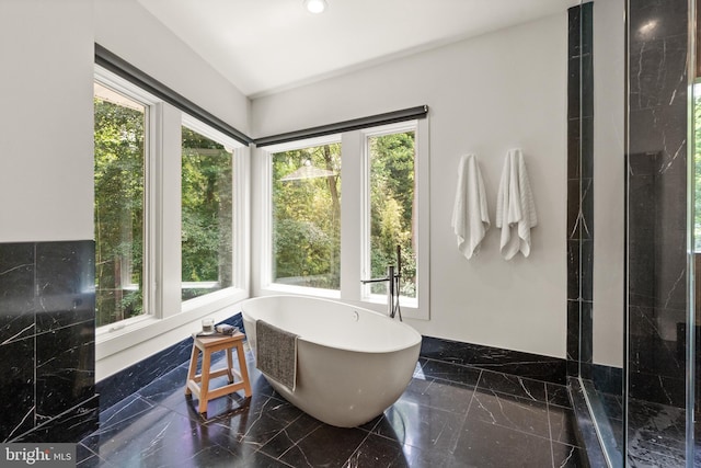 full bath featuring a shower, marble finish floor, and a freestanding tub