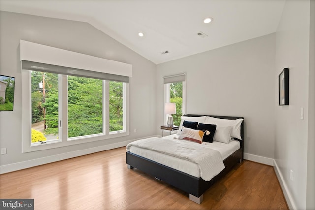 bedroom with visible vents, baseboards, lofted ceiling, wood finished floors, and recessed lighting