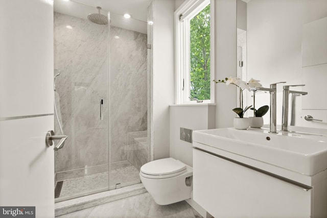 bathroom with toilet, a marble finish shower, and vanity