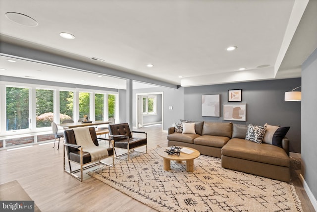 living area with light wood-type flooring, visible vents, baseboards, and recessed lighting