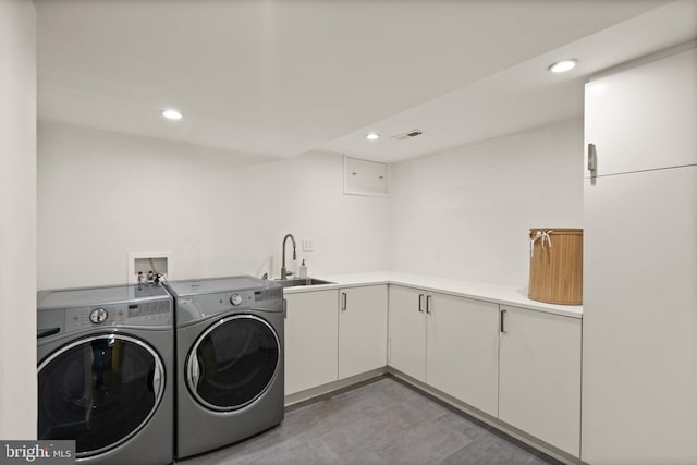 laundry area with cabinet space, visible vents, washer and dryer, a sink, and recessed lighting