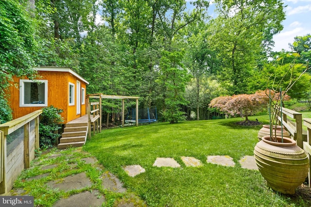 view of yard featuring an outbuilding and a trampoline