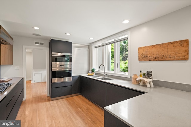 kitchen with a sink, modern cabinets, and dark cabinetry