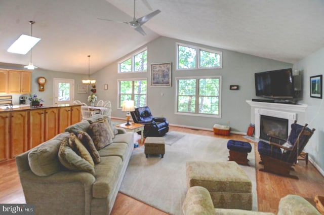 living room with light wood-type flooring, vaulted ceiling, and ceiling fan