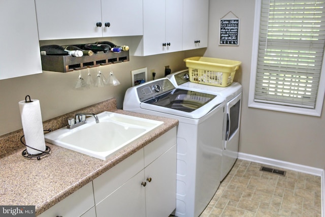 laundry room with sink, cabinets, and independent washer and dryer