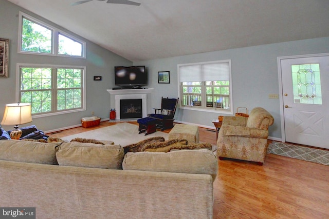 living room featuring hardwood / wood-style flooring, ceiling fan, and vaulted ceiling