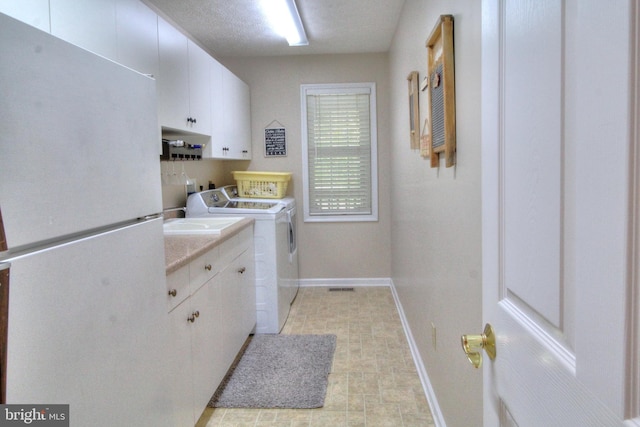 washroom featuring washer and dryer and cabinets