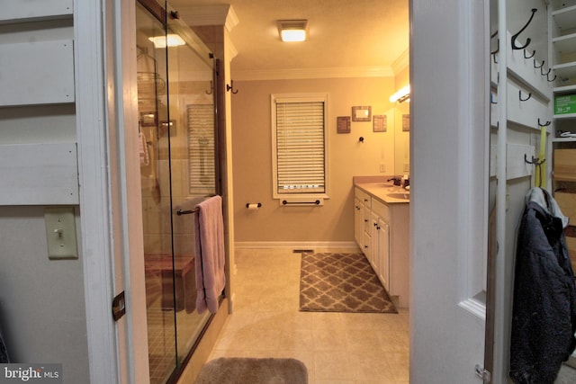 bathroom featuring vanity, a shower with shower door, and crown molding