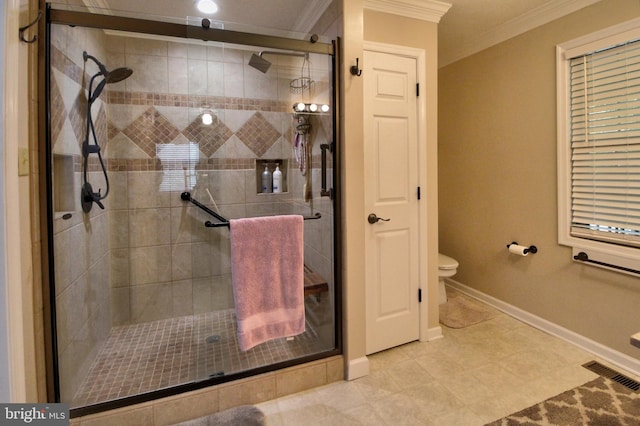 bathroom featuring tile patterned flooring, a shower with shower door, toilet, and ornamental molding