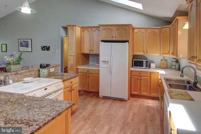 kitchen featuring white appliances, sink, hanging light fixtures, a skylight, and light wood-type flooring