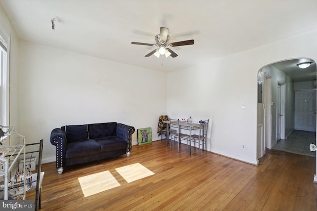 sitting room with ceiling fan and wood-type flooring