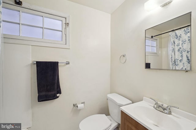 bathroom with a shower with curtain, vanity, and toilet