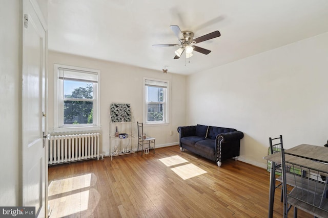 sitting room featuring hardwood / wood-style flooring, ceiling fan, and radiator