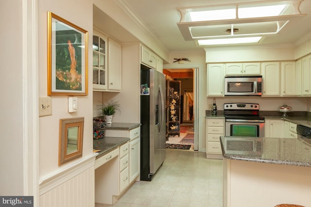 kitchen featuring dark stone countertops, crown molding, and stainless steel appliances