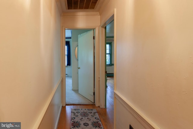 hall featuring ornamental molding and light hardwood / wood-style floors