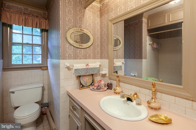 bathroom featuring vanity, tile walls, and toilet