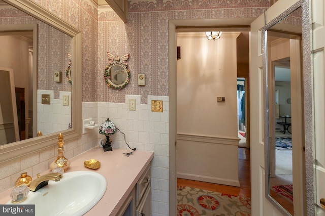 bathroom with hardwood / wood-style floors, vanity, and tile walls