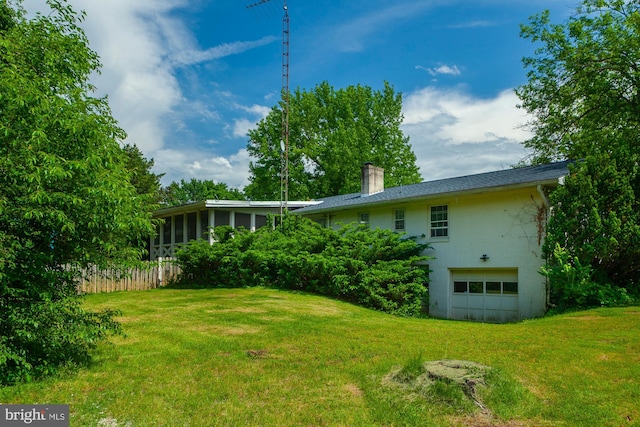 view of yard with a garage and a sunroom