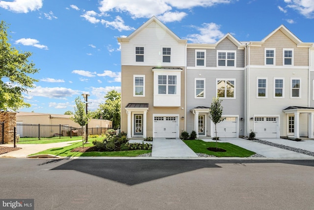 multi unit property featuring a garage, driveway, and fence