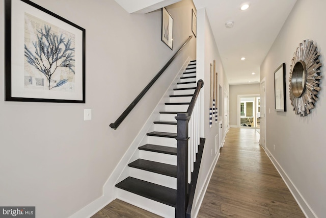 stairway featuring recessed lighting, wood finished floors, and baseboards