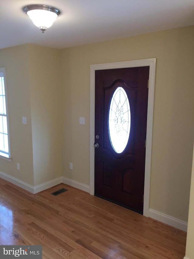 entryway with baseboards, visible vents, and light wood-style floors