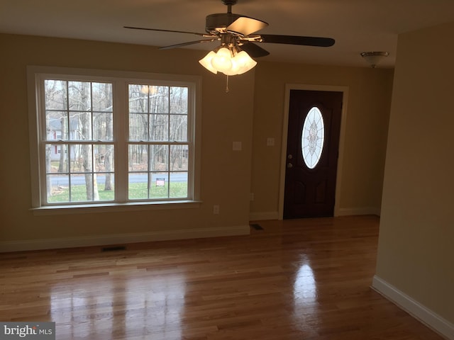 entryway with a ceiling fan, light wood-type flooring, visible vents, and baseboards