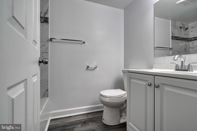 full bathroom featuring hardwood / wood-style floors, vanity, toilet, and tub / shower combination