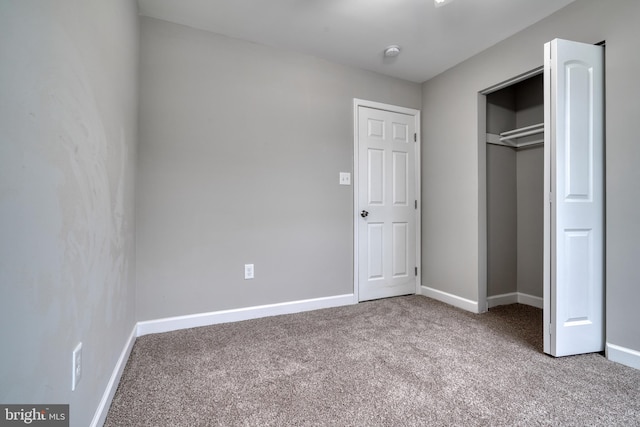 unfurnished bedroom featuring carpet flooring and a closet