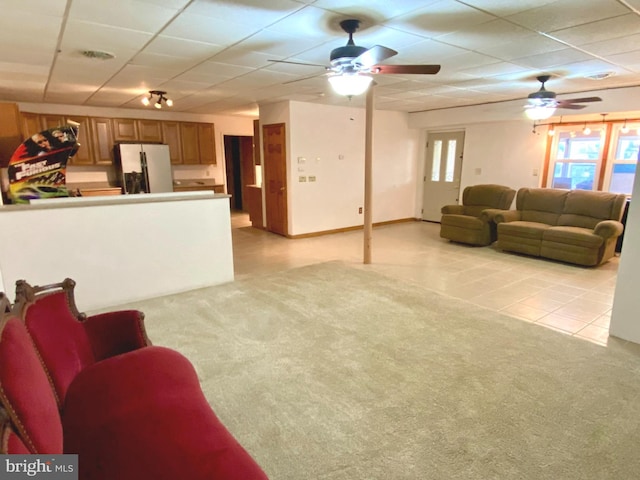 living room featuring light colored carpet, ceiling fan, and a paneled ceiling