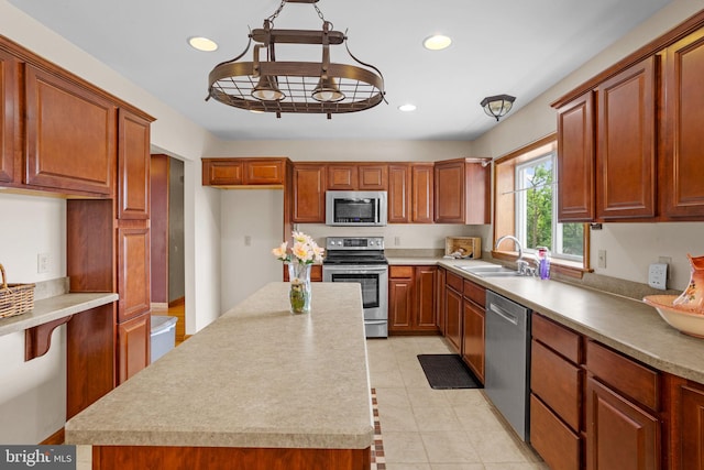 kitchen with light tile patterned flooring, stainless steel appliances, sink, and a kitchen island