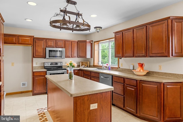 kitchen featuring sink, a center island, stainless steel appliances, and decorative light fixtures