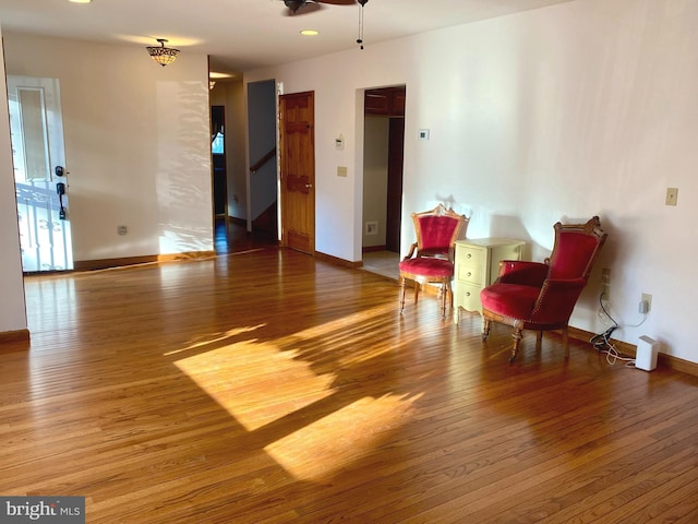 living area with light wood-type flooring and ceiling fan