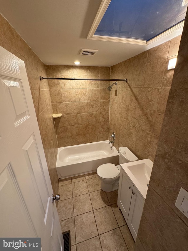 full bathroom with tiled shower / bath combo, vanity, tile patterned flooring, and toilet