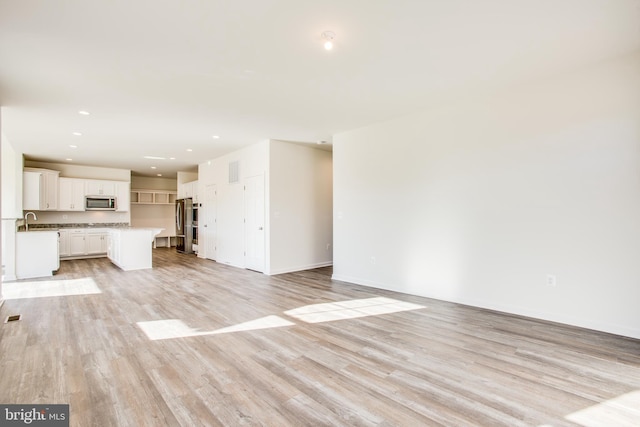 unfurnished living room with light wood-type flooring