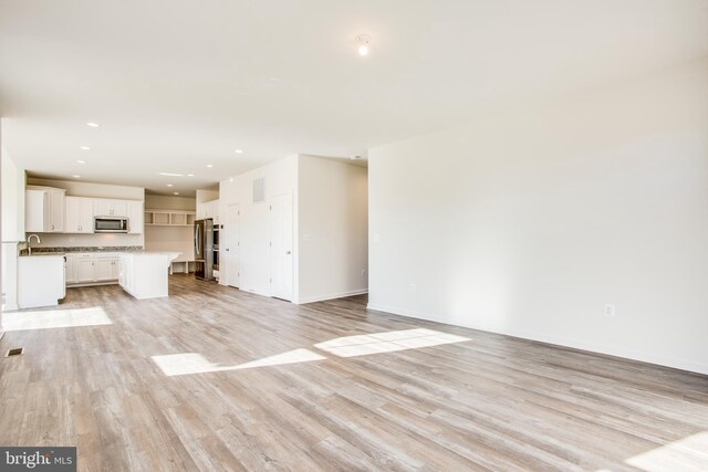 2107 Warrenton Rd, Fredericksburg, VA 22406 - unfurnished living room with light wood finished floors, baseboards, and recessed lighting